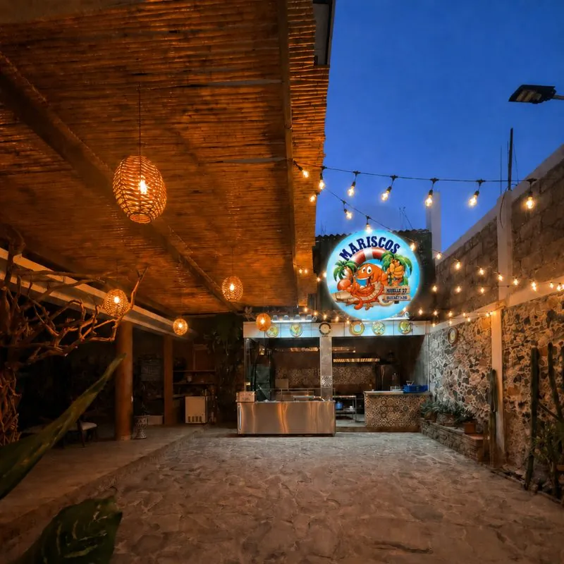 Fachada nocturna de Mariscos Muelle 27 con logo iluminado en Querétaro